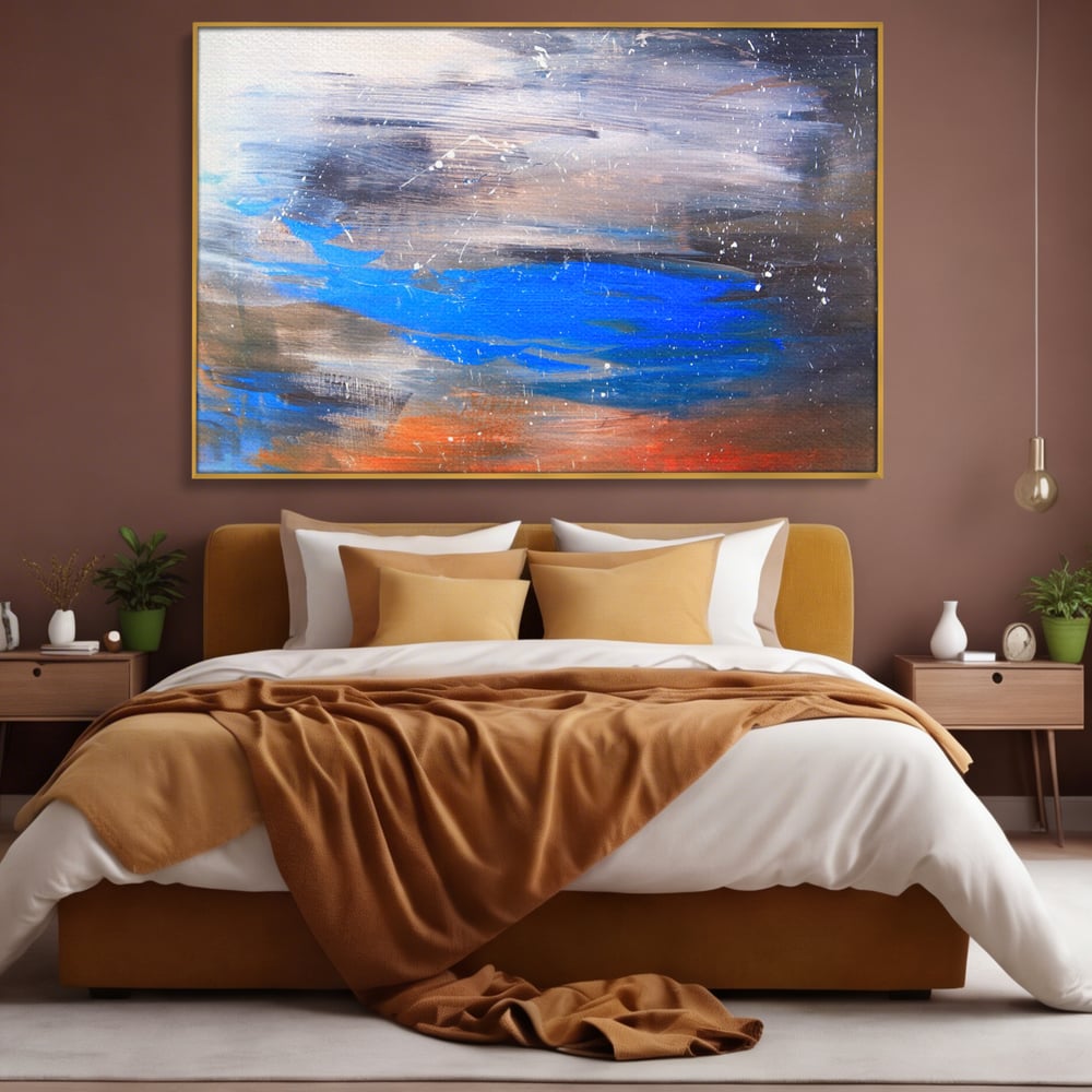Tablou canvas cu pictura abstracta cu pete albastre, in rama de aluminiu auriu, pe perete intr-un dormitor